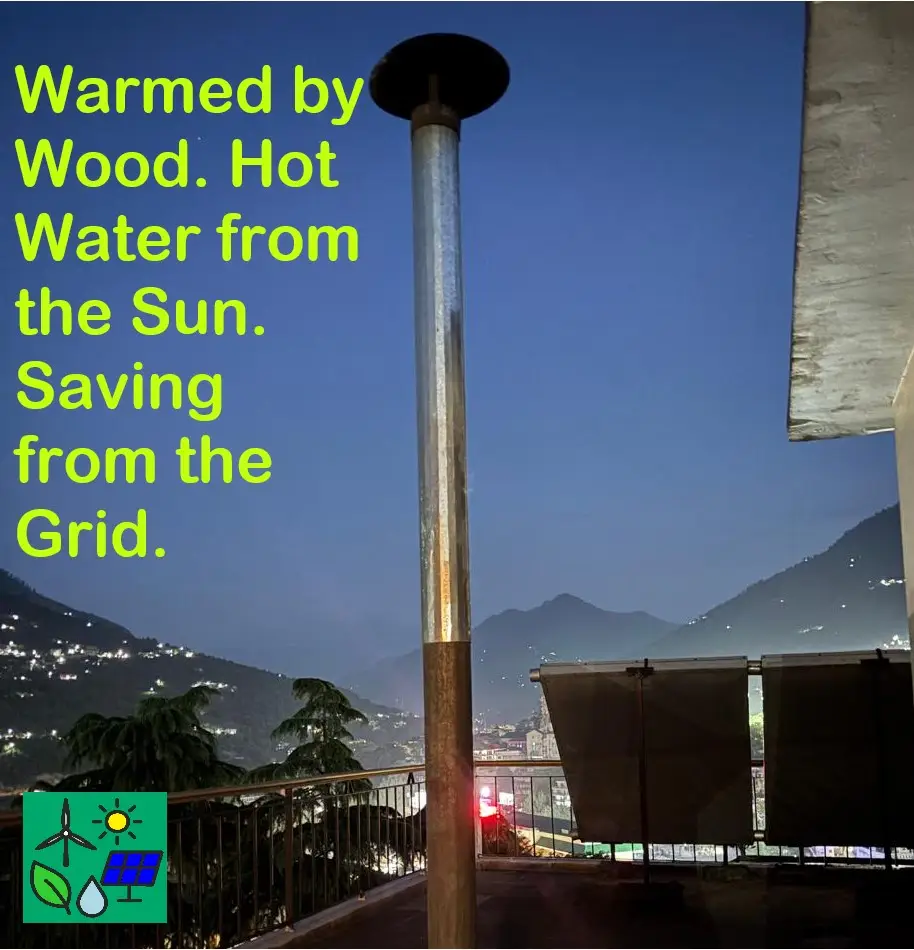 Biomass chimney and solar water heater on a mountain home rooftop at dusk