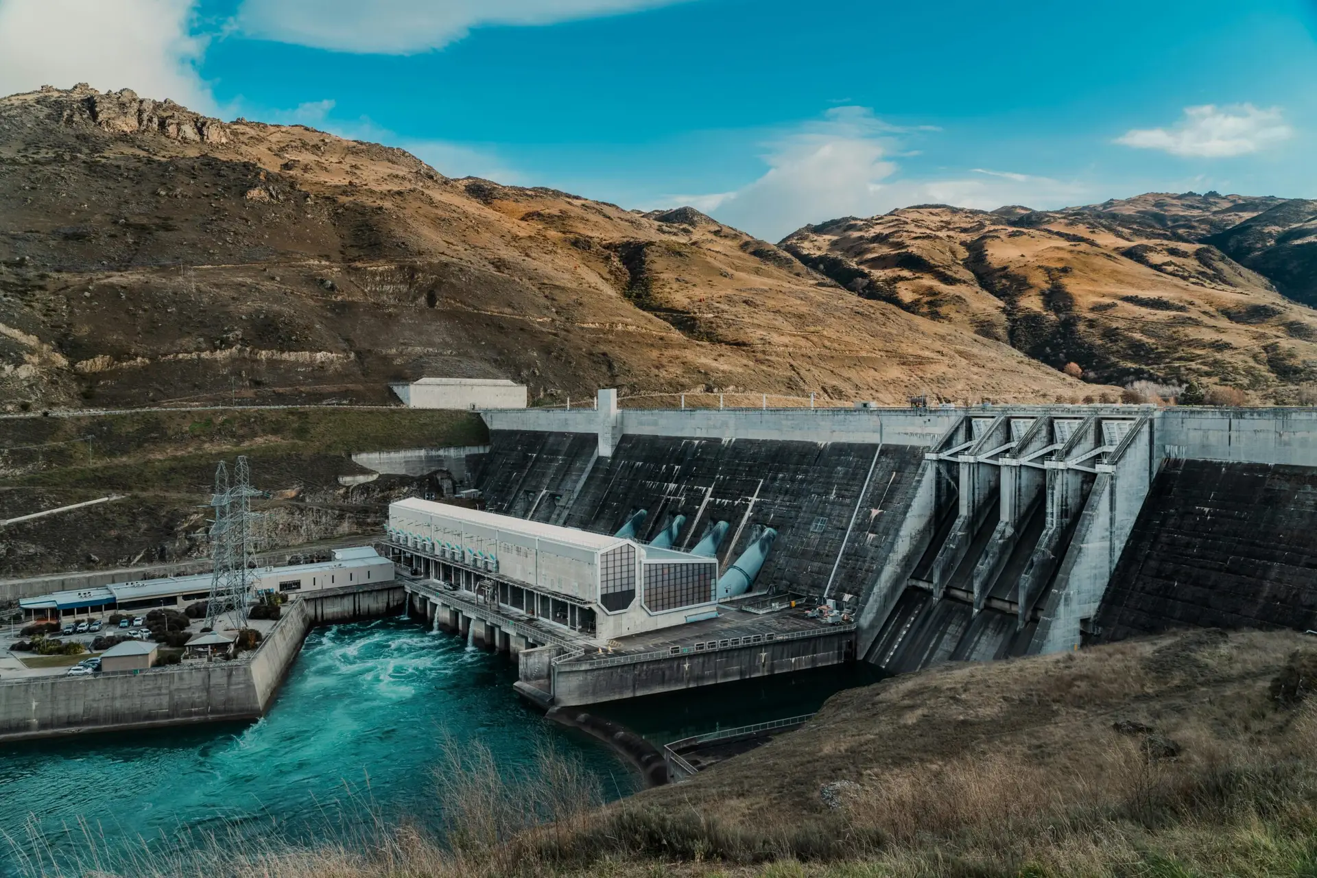 Powerful hydroelectric dam nestled in a rugged mountain landscape with clear blue waters.